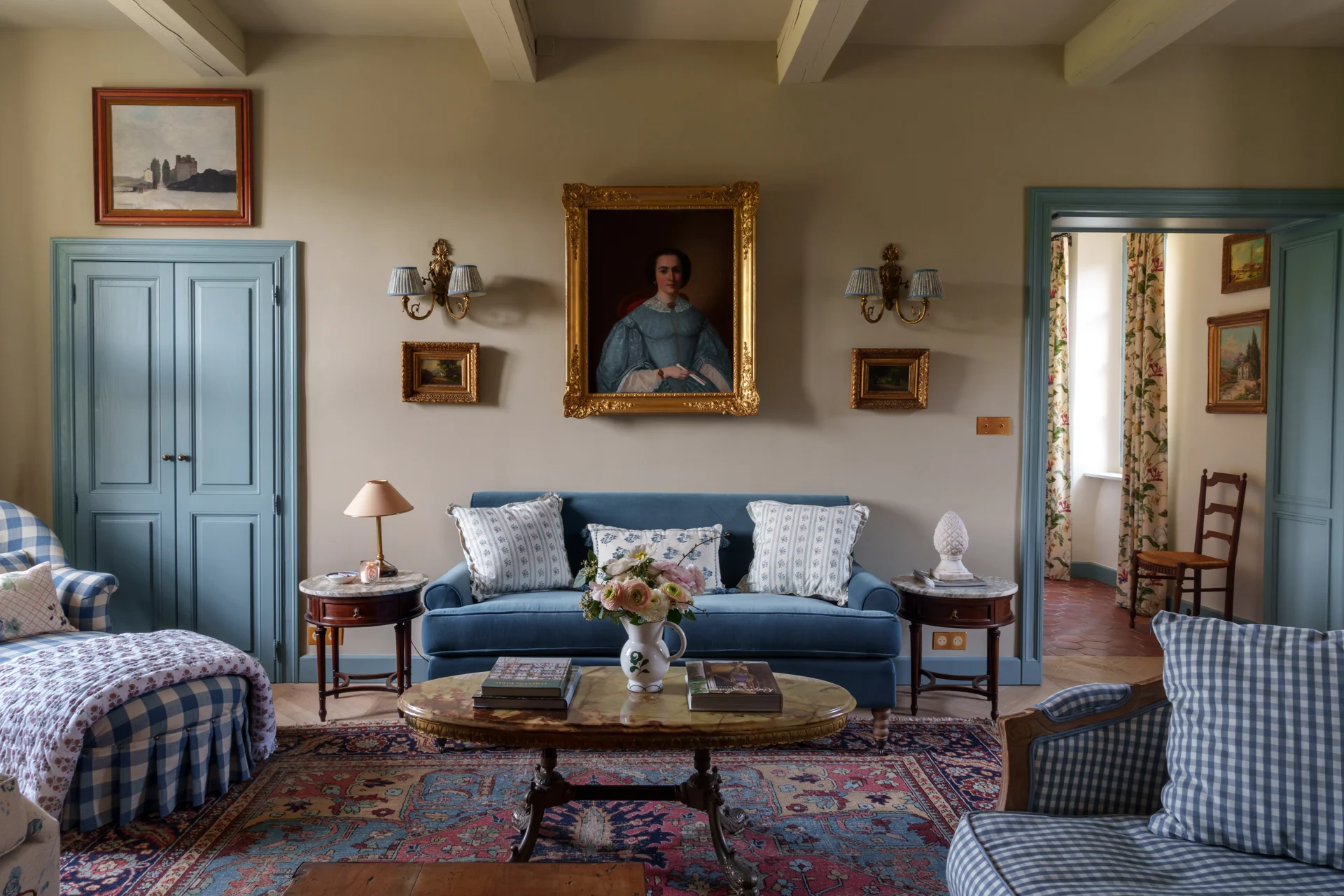 The grand salon at Maison de Frederic — a refined living space with velvet furnishings, gilt-framed paintings, and Provençal character